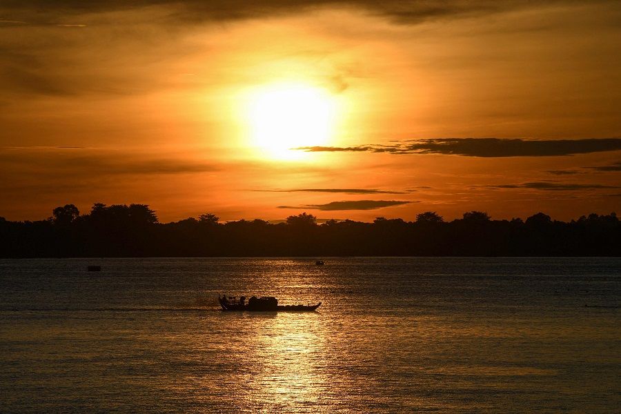 A fisherman operates a fishing boat in the Mekong River in Phnom Penh, Cambodia, on 25 August 2021. (Tang Chhin Sothy/AFP)