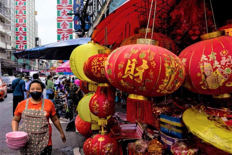 A woman carries a stack of bowls during the annual Vegetarian Festival in the Chinatown area of Bangkok on 7 October 2021. (Jack Taylor/AFP)