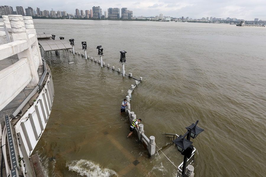 Workers monitor the flood situation along the overflowing Yangtze River in Wuhan, Hubei, China, on 8 July 2020. (STR/AFP)