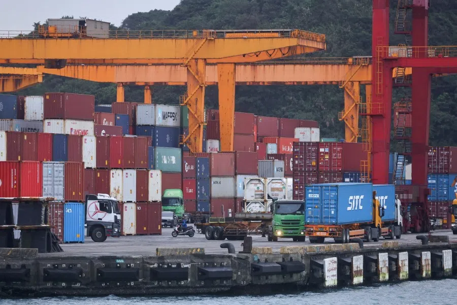 Cargo trucks work inside a container yard in Keelung, Taiwan, 7 January 2022. (Ann Wang/Reuters)