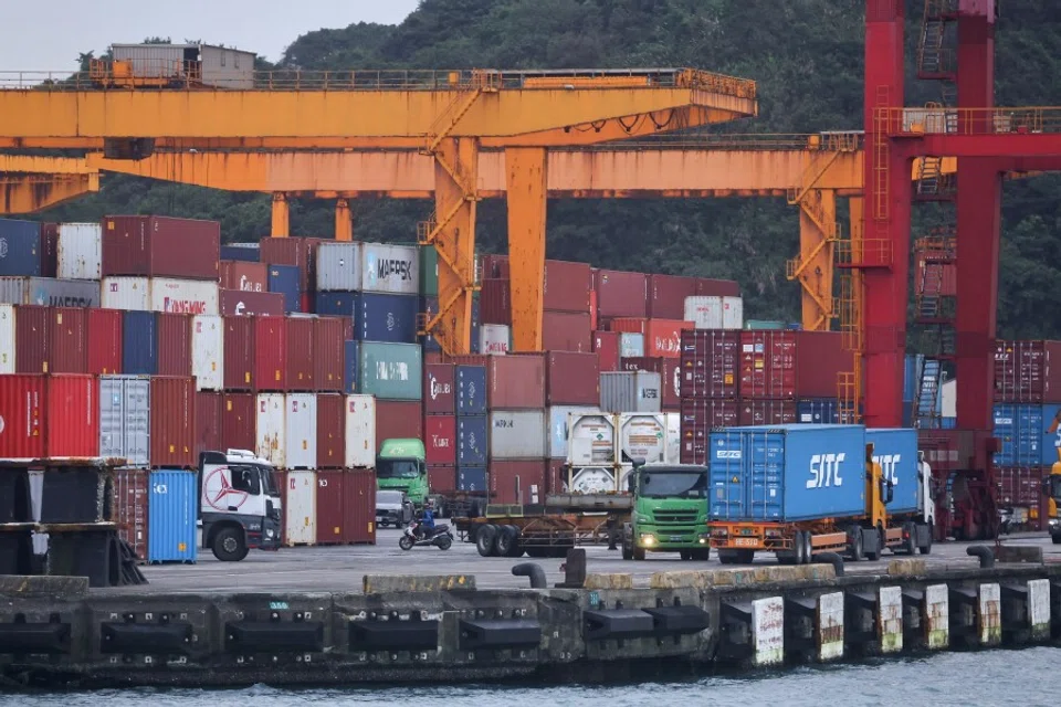 Cargo trucks work inside a container yard in Keelung, Taiwan, 7 January 2022. (Ann Wang/Reuters)