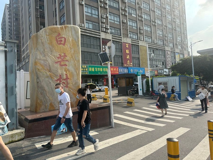 People walk along a street in Baimang village, Nanshan district, Shenzhen, Guangdong province, China.
