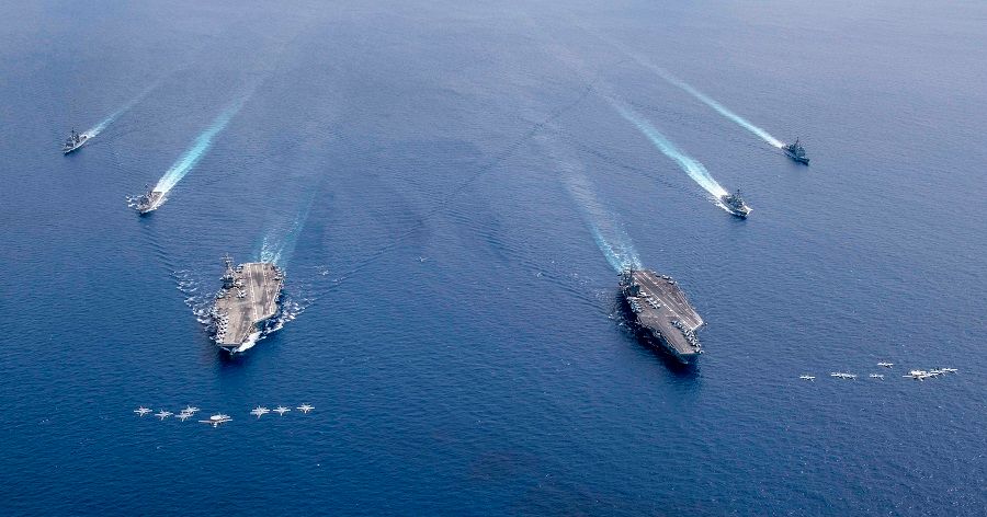 This US Navy photo released on 7 July 2020 shows aircraft from Carrier Air Wings (CVW) 5 and 17 as they fly in formation over the Nimitz Carrier Strike Force, the aircraft carriers USS Nimitz (CVN 68) (right), and USS Ronald Reagan (CVN 76) as their carrier strike groups are conducting dual carrier operations in the Indo-Pacific as the Nimitz Carrier Strike Force on 6 July 2020. (Keenan Daniels/US Navy/AFP)