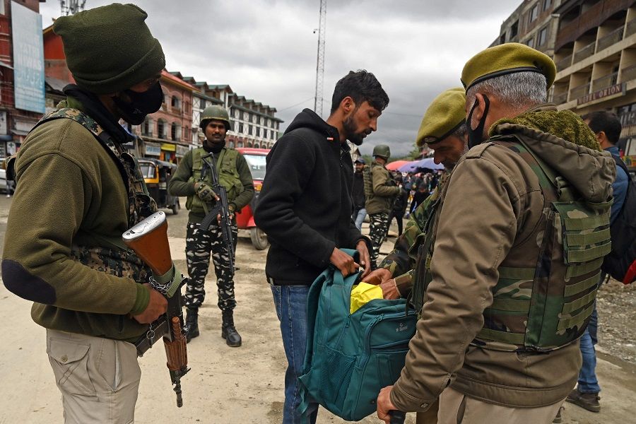 Indian security personnel searches the bag of a pedestrian during a random search in Srinagar on 20 April 2023. (Tauseef Mustafa/AFP)