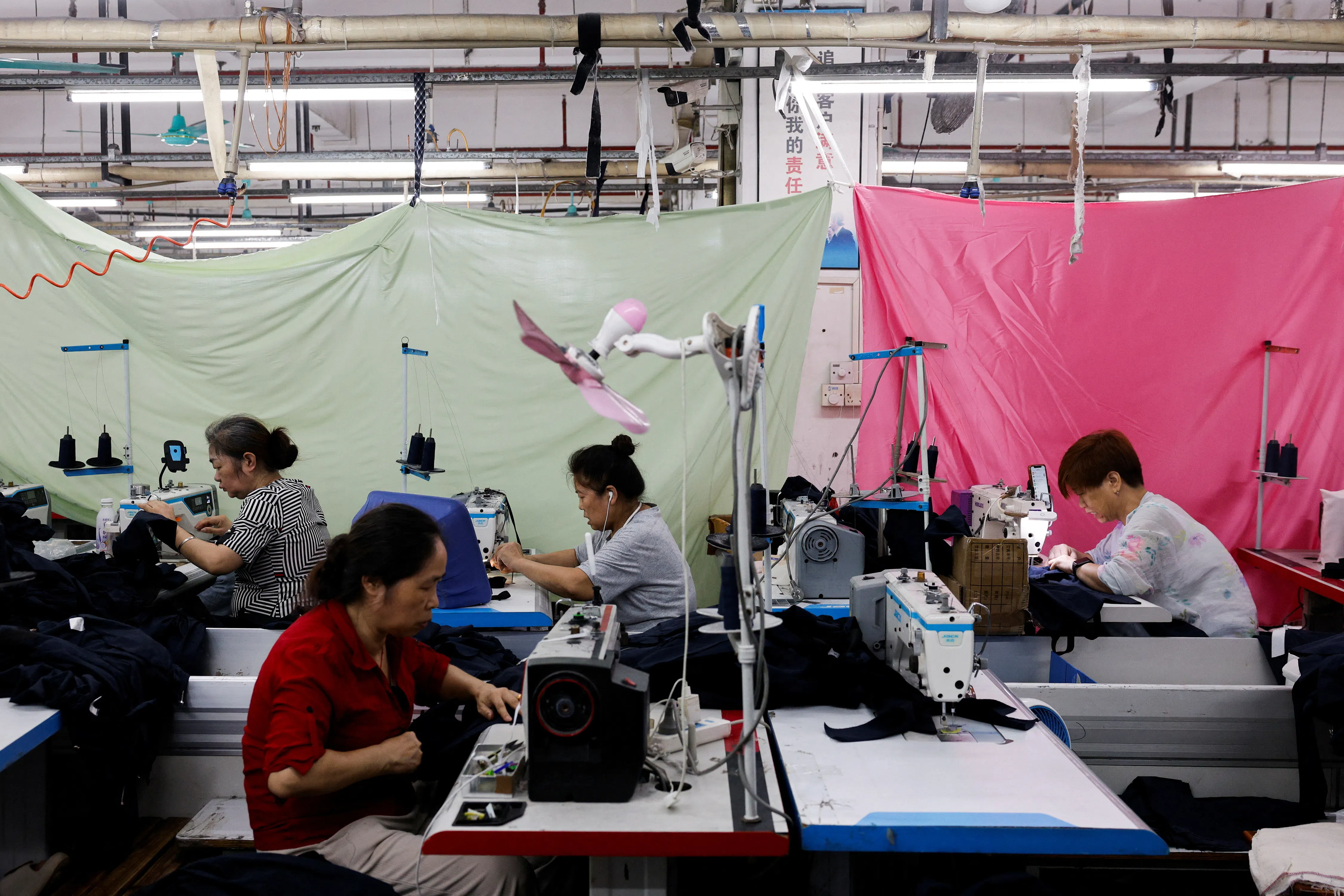 Employees work on a production line at a garment factory in Panyu district, Guangzhou, Guangdong province, China, on 27 July 2026.