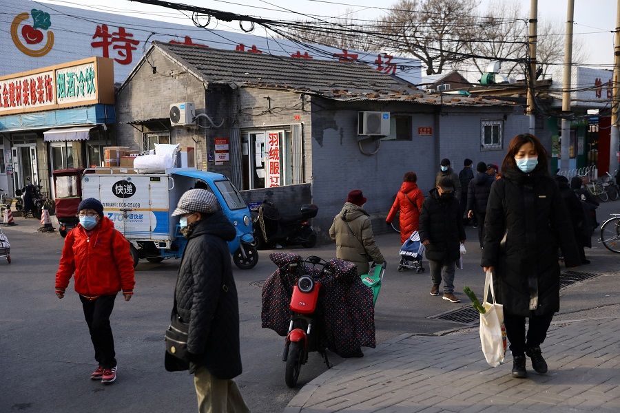 People walk on a street in Beijing, China, 14 January 2022. (Tingshu Wang/Reuters)