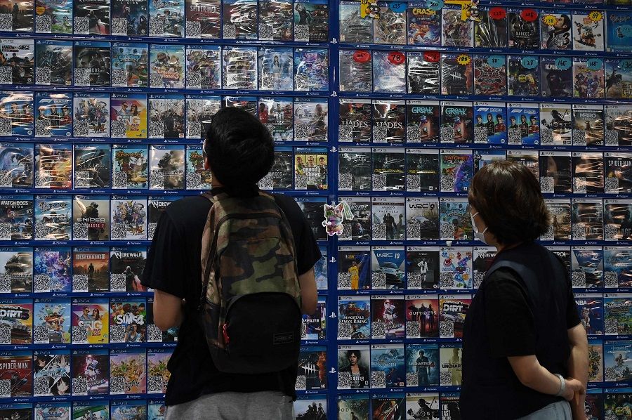 Customers browse computer games at a store in Beijing, China on 10 September 2021. (Greg Baker/AFP)