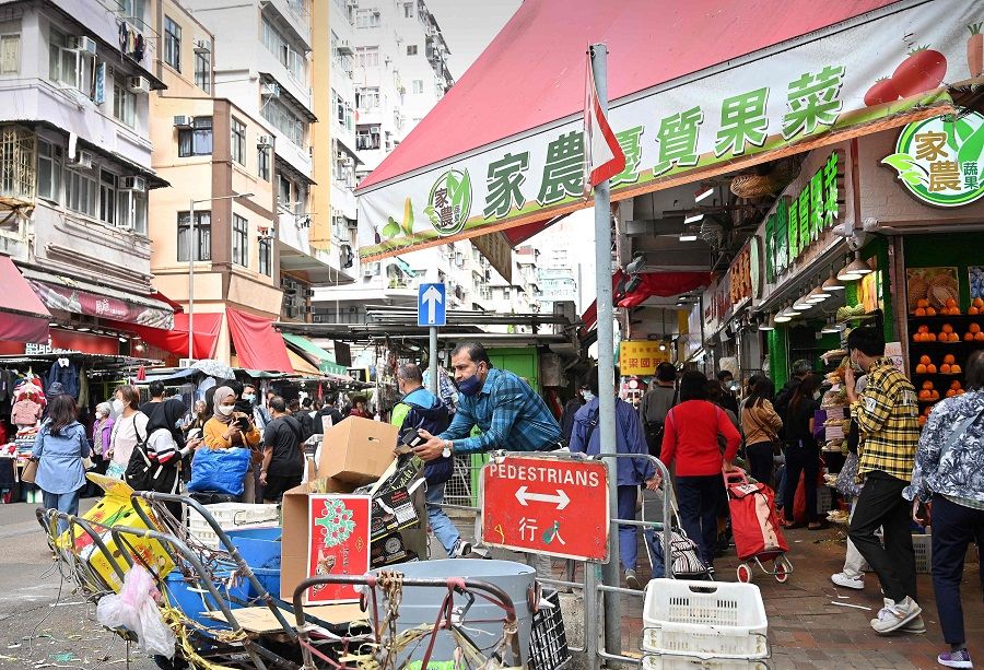 Shoppers walk through a market street in Kowloon district of Hong Kong, China, on 4 December 2022. (Peter Parks/AFP)