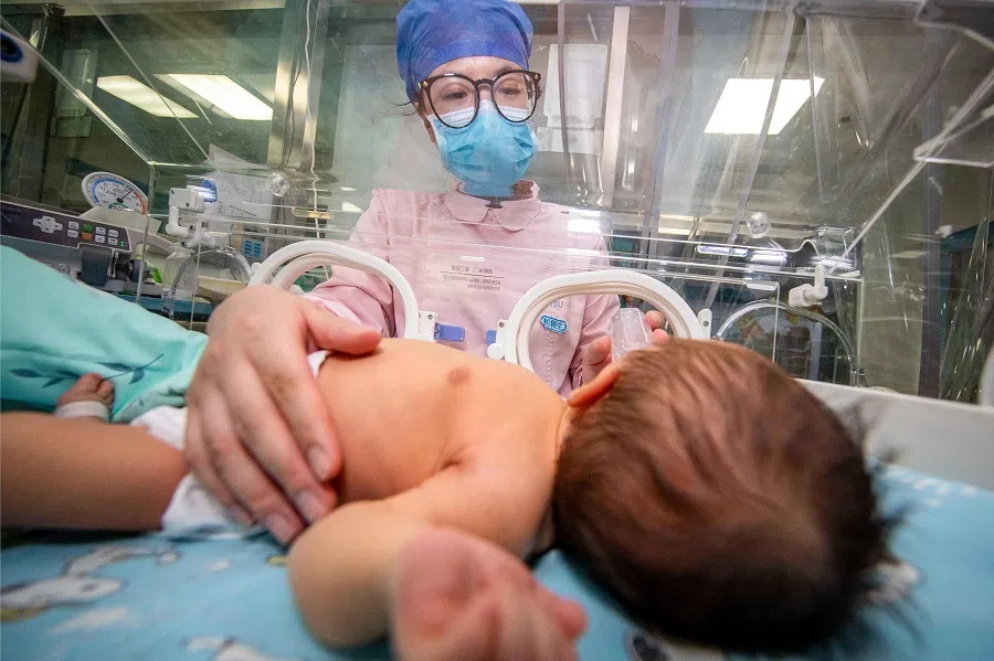 A nurse takes care of a newborn baby at a hospital in Taizhou, Jiangsu province, China on 12 May 2023. (AFP)