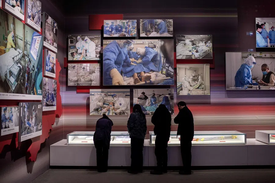 In this picture taken on 15 January 2021, people visit an exhibition about China's fight against the Covid-19 coronavirus at a convention centre that was previously used as a makeshift hospital for patients in Wuhan. (Nicolas Asfouri/AFP)