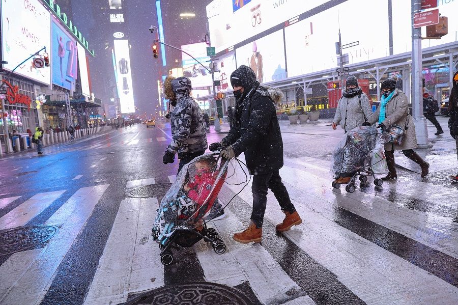 Pedestrians cross a street in the Times Square neighbourhood of New York, US, 16 December 2020. (Angus Mordant/Bloomberg)