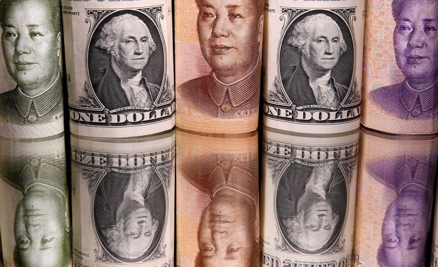 Chinese Yuan and US dollar banknotes are seen in this illustration taken 10 February 2020. (Dado Ruvic/Reuters)