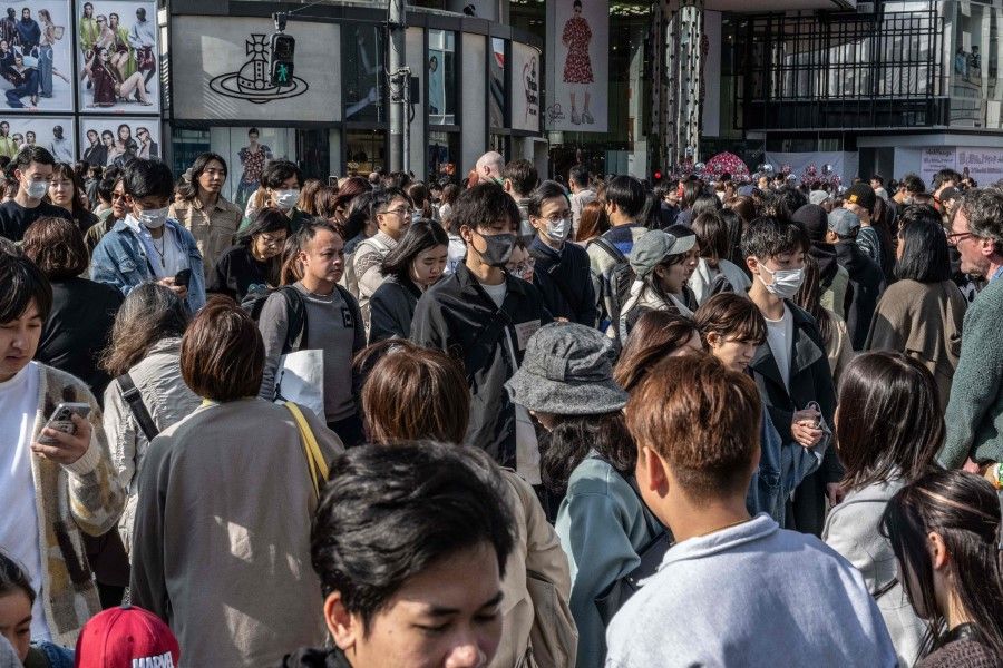 People cross a street in the Omotesando area of Tokyo on 17 March 2024. (Yuichi Yamazaki/AFP)