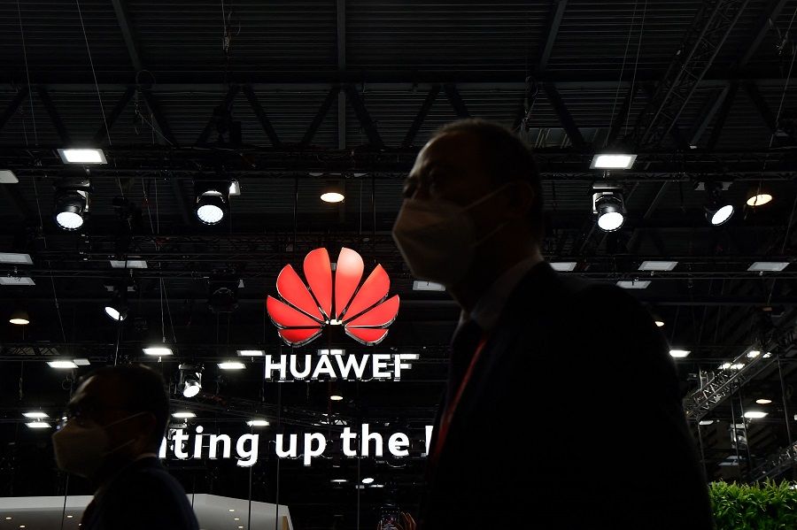 Visitors walk by the Huawei stand at the Mobile World Congress (MWC) fair in Barcelona on 28 June 2021. (Pau Barrena/AFP)