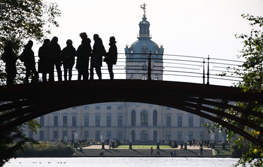 People take a walk at the gardens at Charlottenburg Castle in Berlin, Germany, on 20 October 2022. (Tobias Schwarz/AFP)