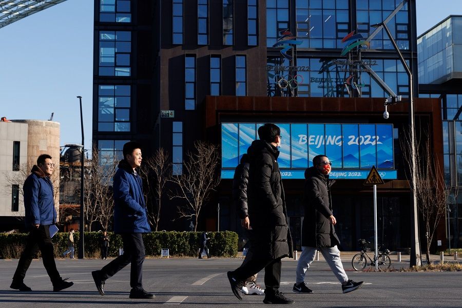 People walk past the headquarters of the Beijing Organising Committee for the 2022 Olympic and Paralympic Winter Games in Shougang Park, in Beijing, China, 30 November 2021. (Thomas Peter/Reuters)