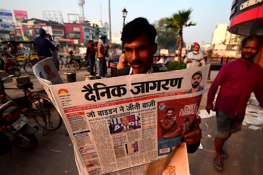 A man reads a morning newspaper showing a photograph of US President-elect Joe Biden, on a street in Allahabad, India, on 8 November 2020. (Sanjay Kanojia/AFP)
