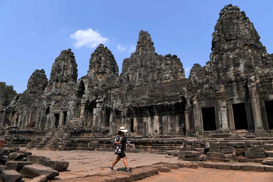 This picture taken on March 5, 2020 shows a tourist visiting Bayon temple in Siem Reap province. The Covid-19 epidemic will cost world tourism at least $22 billion owing to a drop in spending by Chinese tourists, the head of the World Travel and Tourism Council said on February 27. (Tang Chhin Sothy/AFP)