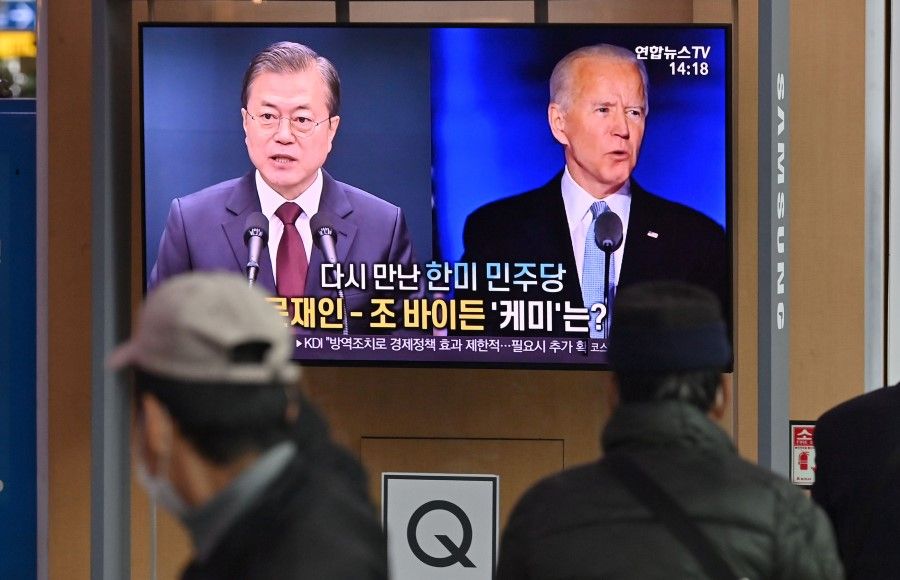 People watch a television news programme reporting on the US presidential election showing images of US President-elect Joe Biden (right) and South Korean President Moon Jae-in, at a railway station in Seoul on 9 November 2020. (Jung Yeon-je/AFP)
