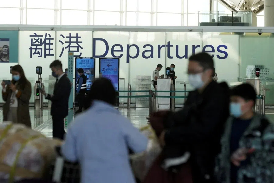 Passengers wearing face masks stand at the departures hall of Hong Kong International Airport, following infections of the coronavirus disease (Covid-19) in Hong Kong, China, 11 January 2022. (Lam Yik/Reuters)