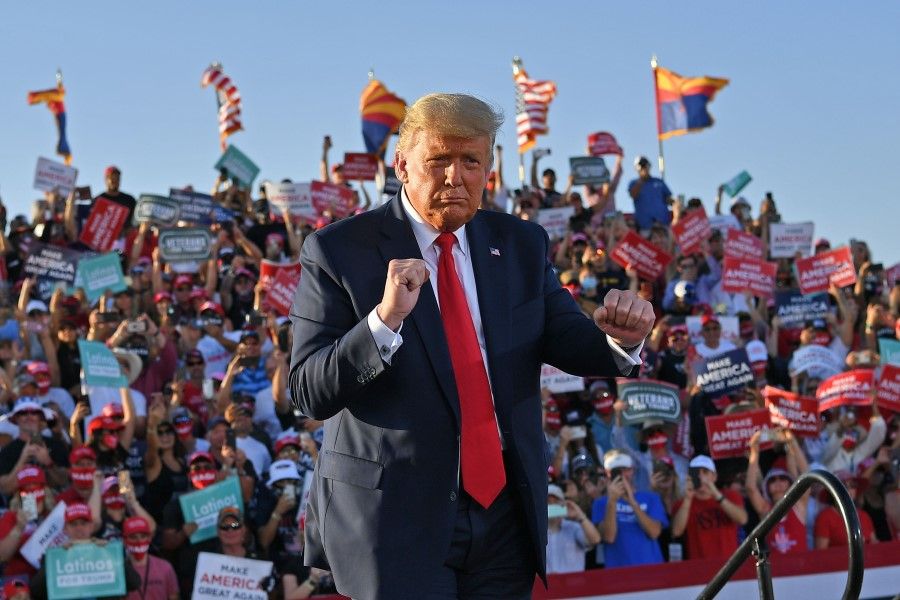 In this file photo taken on 19 October 2020, US President Donald Trump dances as he leaves a rally at Tucson International Airport in Tucson, Arizona. (Mandel Ngan/AFP)