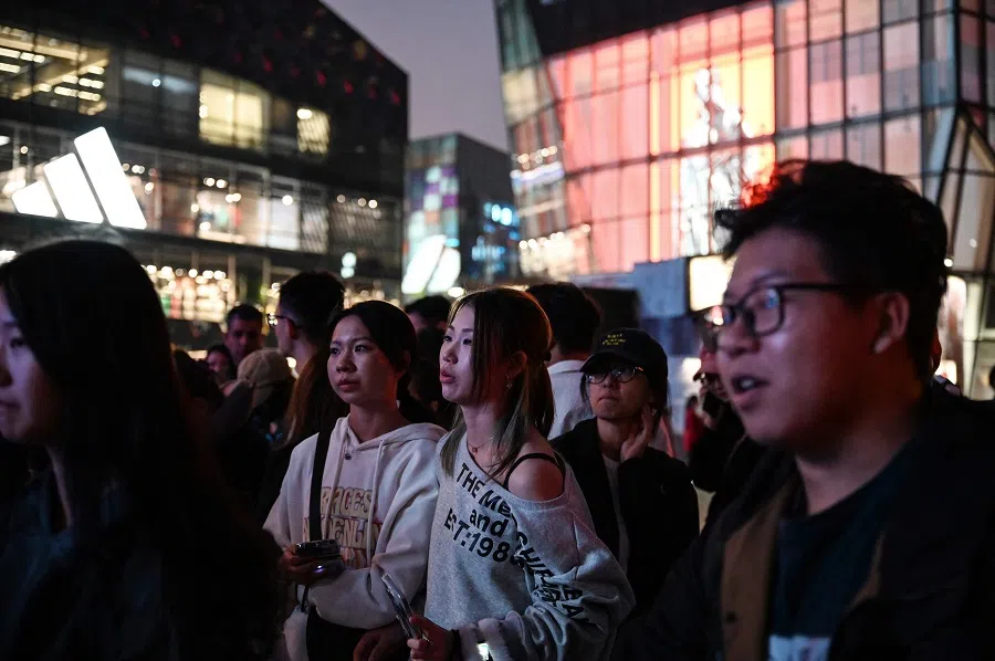 People wait outside a shopping mall in Beijing, China, on 4 October 2024. (Greg Baker/AFP)