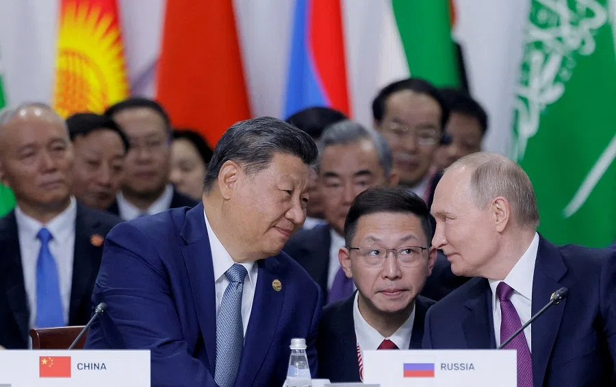 Russian President Vladimir Putin and Chinese President Xi Jinping speak during a plenary session in the outreach/BRICS Plus format at the BRICS summit in Kazan, Russia, on 24 October 2024. (Maxim Shemetov/Pool/Reuters)