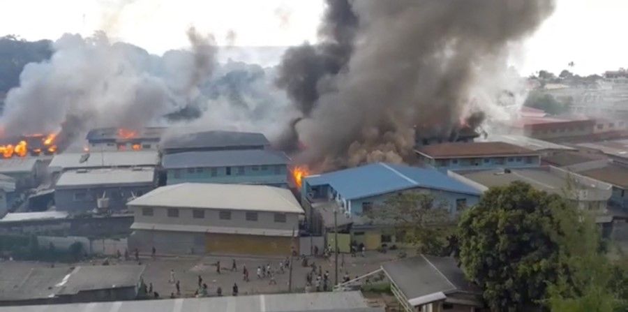 Smoke rises from burning buildings in Chinatown of Solomon Islands' capital Honiara, Solomon Islands, 25 November 2021 in this picture obtained from a social media video. (@Zfm Radio My Favourite Music Station via Reuters)