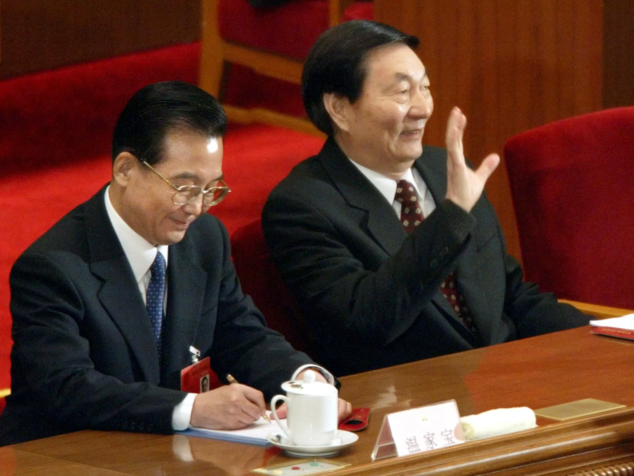 China's former Premier Zhu Rongji (right), sitting next to his successor Wen Jiabao, acknowledges delegates' applause as he arrives at a session of the National People's Congress, in Beijing, on 16 March 2003.