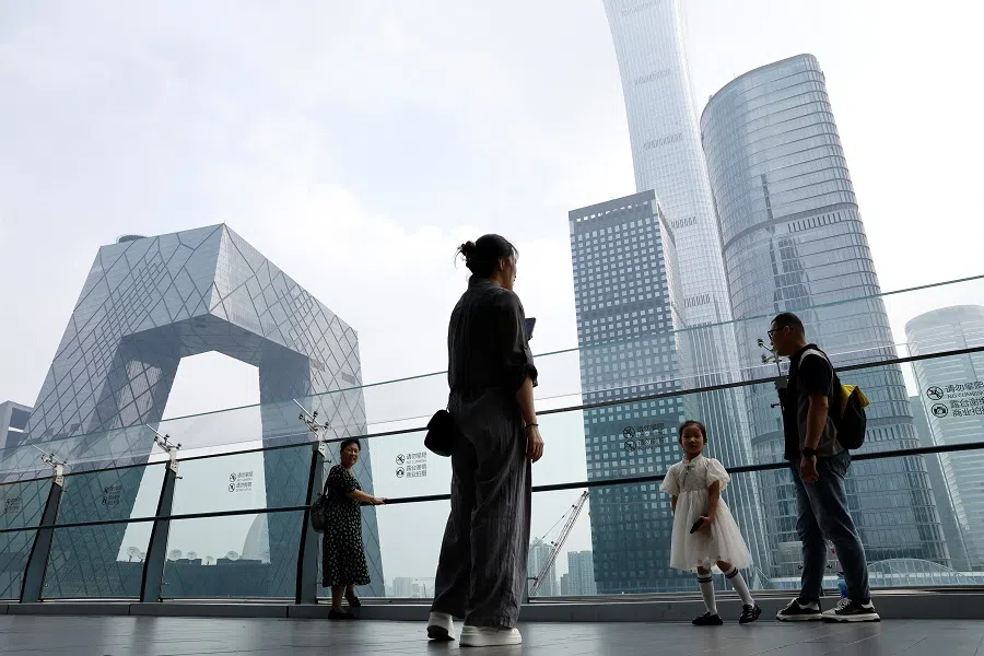 People stand at a shopping mall near the CCTV headquarters and China Zun skyscraper, in Beijing's central business district, China, 7 September 2023. (Reuters/Tingshu Wang)
