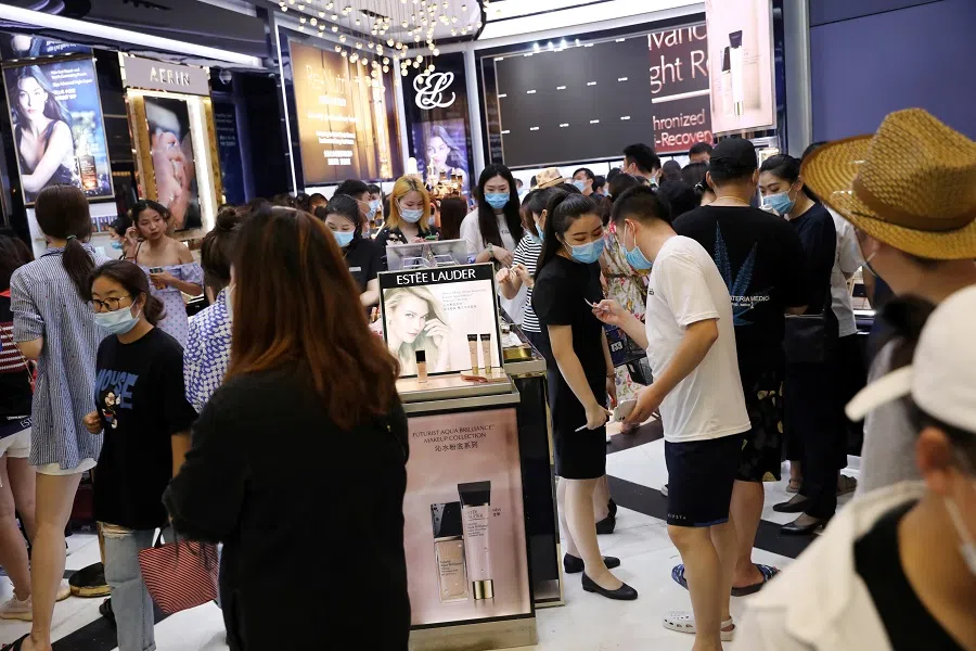 People wearing face masks shop at a cosmetics store inside the Sanya International Duty Free Shopping Complex in Sanya, Hainan province, China, 25 November 2020. (Tingshu Wang/File Photo/Reuters)