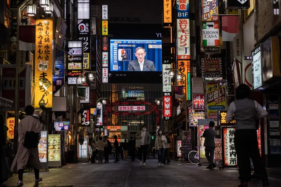 A screen shows Japanese Prime Minister Yoshihide Suga speaking at a press conference in Tokyo on 7 May 2021. (Yuki Iwamura/AFP)