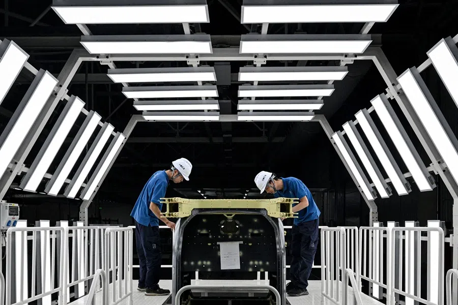 Employees work on a production line at a factory of Xpeng's subsidiary Aridge in Guangzhou, in southern China’s Guangdong province on 6 November 2025. (Jade Gao/AFP)