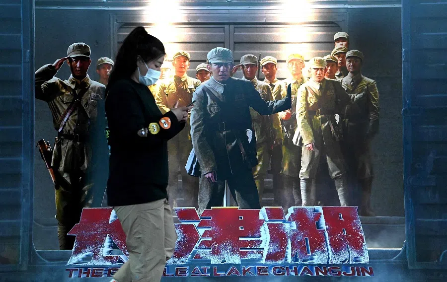 A woman walks past a movie promotion poster or The Battle at Lake Changjin at a mall in Beijing, China, on 11 October 2021. (Noel Celis/AFP)