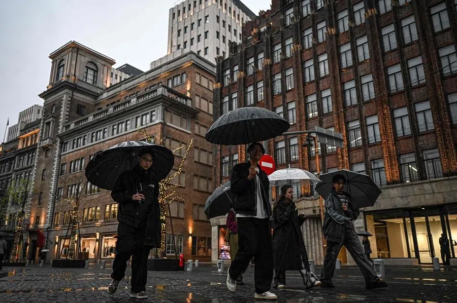 People use umbrellas to shelter from the rain in Shanghai on 3 April 2026. (AFP)
