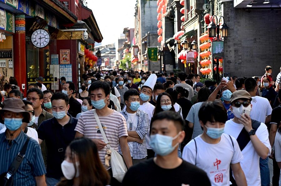 People walk in Qianmen street in Beijing, China, on 21 September 2021. (Noel Celis/AFP)