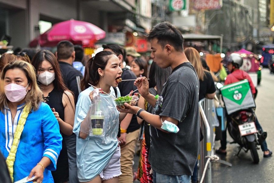 A couple eats street food in the Chinatown area of Bangkok on 9 June 2023. (Manan Vatsyayana/AFP)