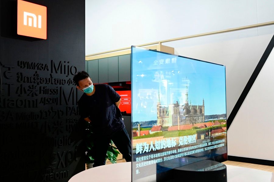 A man looks at a Xiaomi TV at the Chinese technology company Xiaomi booth at the China National Convention Centre, the venue for the upcoming the China International Fair for Trade in Services (CIFTIS) in Beijing on 3 September 2020. (Wang Zhao/AFP)