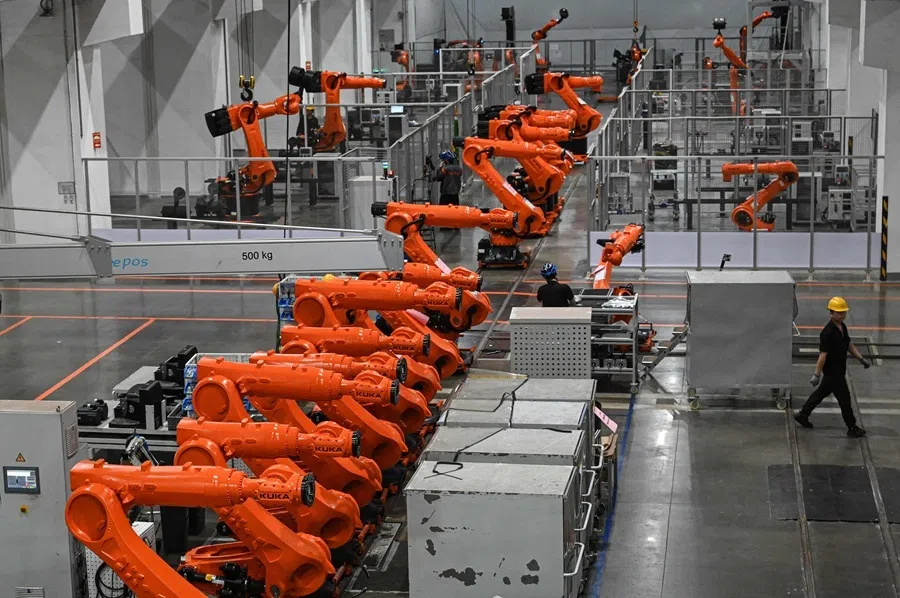 Workers working on an industrial robot assembly line at a KUKA factory in Foshan on 17 March 2026.