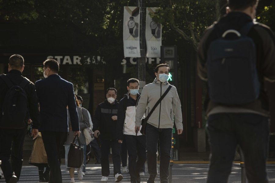 Pedestrians in Shanghai, China, on 10 October 2022. (Qilai Shen/Bloomberg)