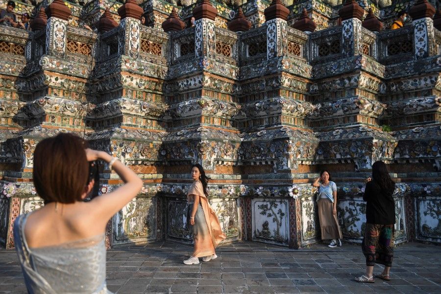 Tourists from mainland China dressed in traditional Thai costumes visit Wat Arun temple ahead of the Chinese Lunar New Year as China reopens the border in Bangkok, Thailand, 18 January 2023. (Chalinee Thirasupa/Reuters)