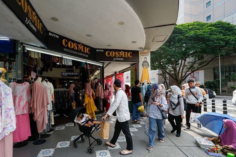 Shoppers walk towards a shopping center in Kuala Lumpur, Malaysia, on 22 March 2024. (Samsul Said/Bloomberg)