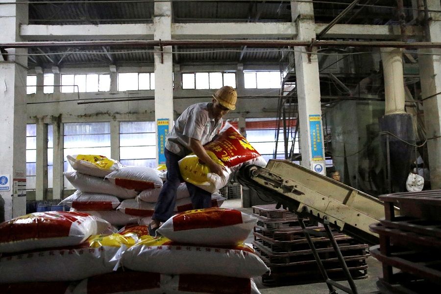 An employee moves a sack of pig feed inside a feed plant of the New Hope Liuhe in Xichang, in Liangshan Yi Autonomous Prefecture, Sichuan province, China, 11 September 2020. (Tingshu Wang/Reuters)