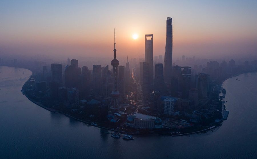 The sun rising behind the skyline of Shanghai's Lujiazui Financial District of Pudong (Johannes Eisele / AFP）
