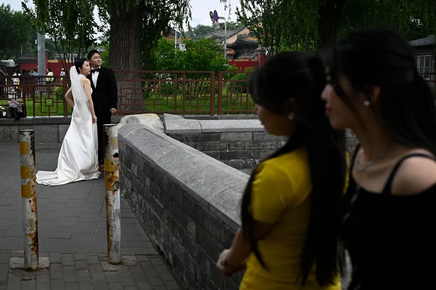 A couple looks on during their wedding picture shoot outside the Forbidden City in Beijing, China on 22 May 2025. (Wang Zhao/AFP)
