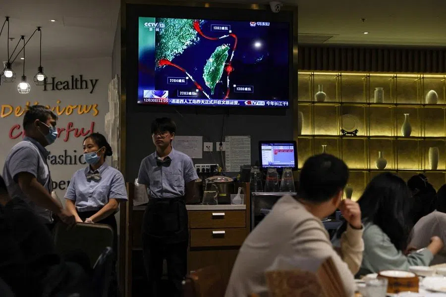 People dine near a television screen showing a news report on patrol and law enforcement operations around Taiwan conducted by China's Fujian Coast Guard, at a restaurant in Beijing, China, on 30 December 2025. (Tingshu Wang/Reuters)