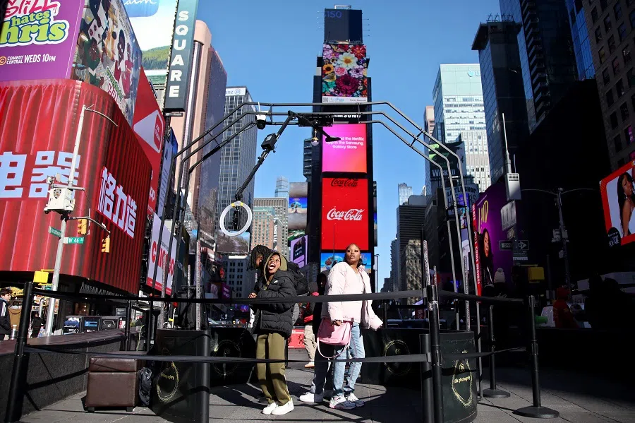 People are recording themselves for social media at Times Square in New York City on 17 January 2025. (Leonardo Munoz/AFP)