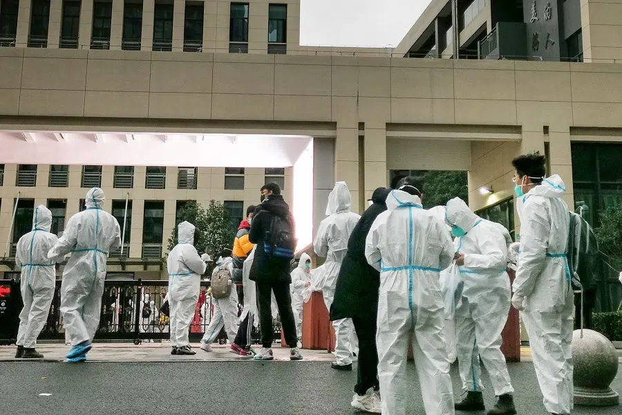 Students wearing personal protective equipment arrive for a college entrance examination in Ningbo, Zhejiang province, China, on 6 January 2022. (AFP)