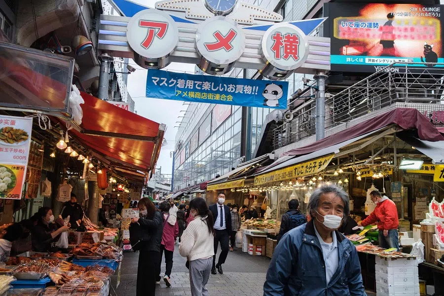 People walk through a street at the Ameyoko market in Ueno district of Tokyo, Japan, on 6 April 2021. (Yuki Iwamura/AFP)