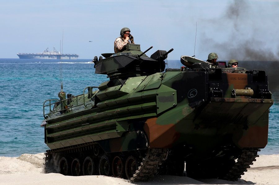 With the USS-Wasp in the background, US Marines ride an amphibious assault vehicle during the amphibious landing exercises of the US-Philippines war games promoting bilateral ties at a military camp in Zambales province, Philippines, on 11 April 2019. (Eloisa Lopez/File Photo/Reuters)